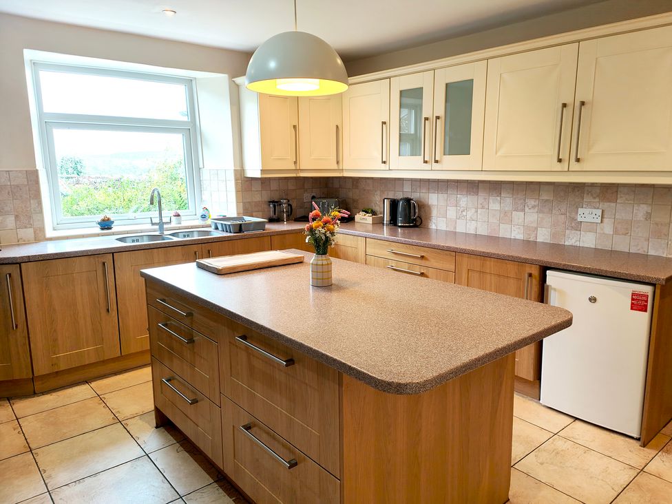 A kitchen with an island and sink at Bush Nook House in Brampton