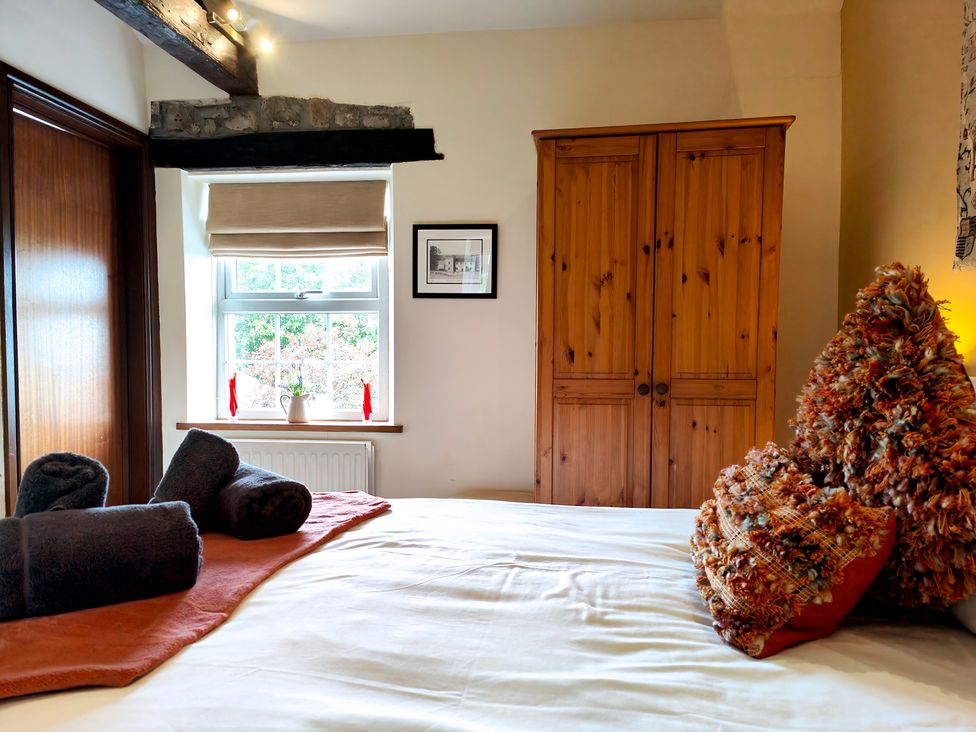 A bedroom with a bed and towels at Bush Nook House in Brampton