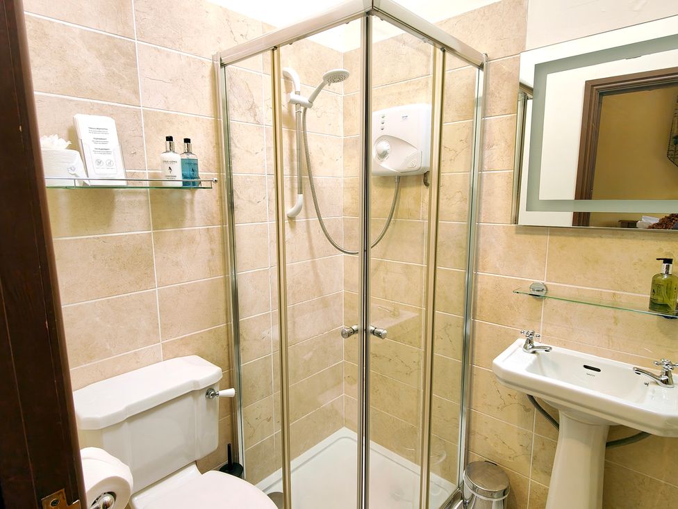 A bathroom with a shower, toilet, and sink at Bush Nook House in Brampton