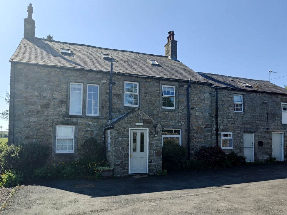 A stone house with windows and a door at Bush Nook House, Brampton, Cumbria