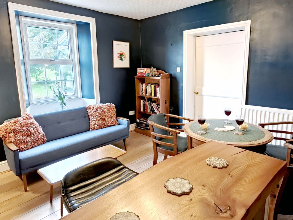 A dining room with a sofa and table at Bush Nook House, Brampton, Cumbria