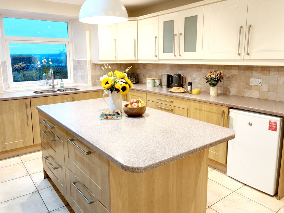 A kitchen with a countertop and cabinets at Bush Nook House in Brampton, Cumbria