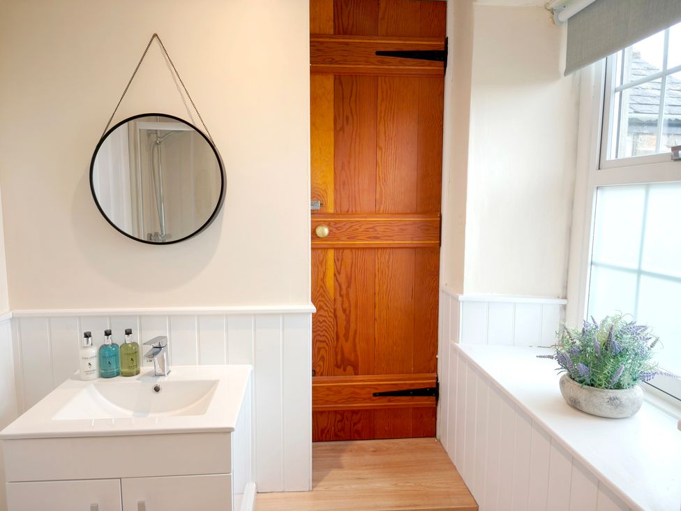 A bathroom with a sink and mirror at Bush Nook House in Brampton, Cumbria