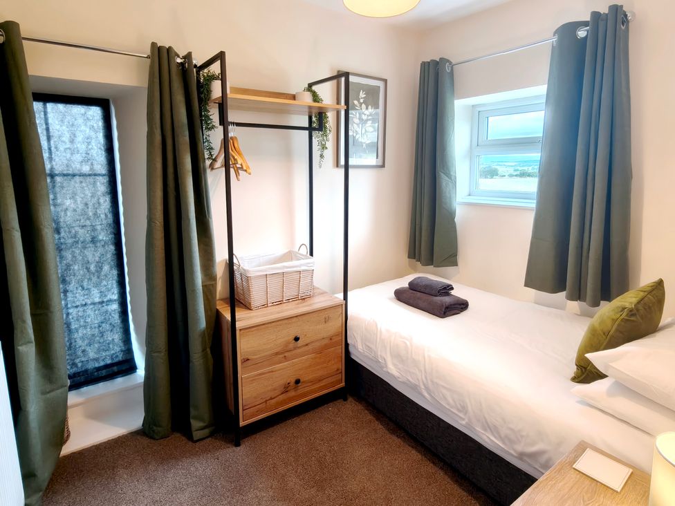 A bedroom with a bed and clothing storage at Bush Nook House in Brampton, Cumbria