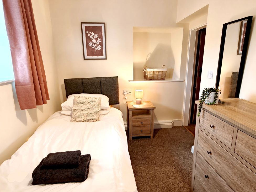 A bedroom with a single bed and bedside table at Bush Nook House in Brampton, Cumbria
