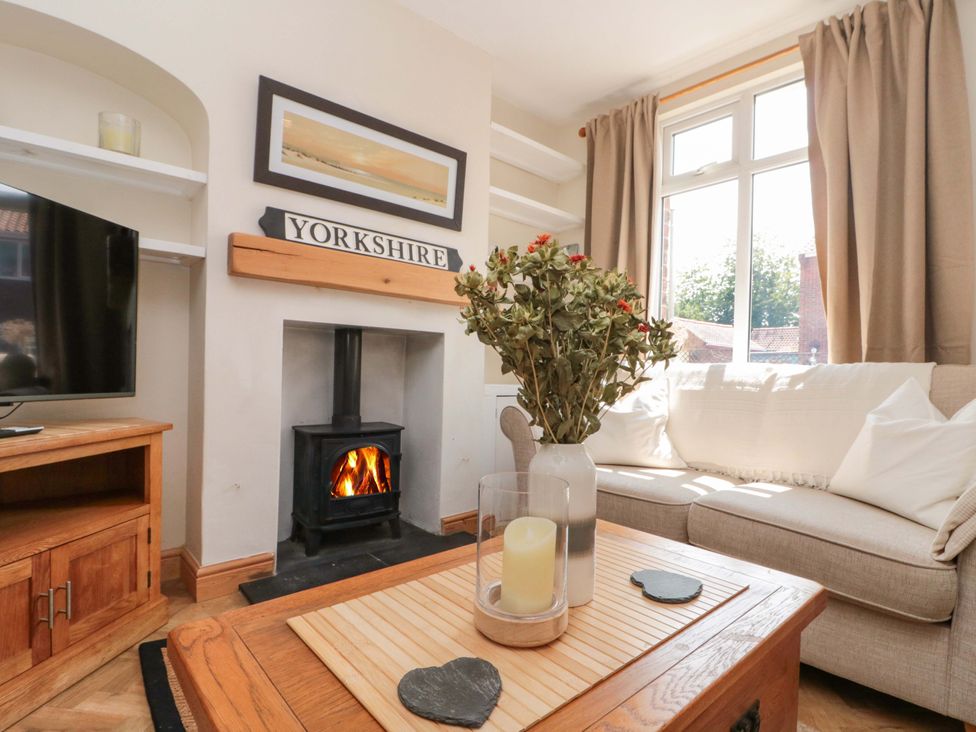 A living room with a sofa and television at Moot Cottage in Driffield