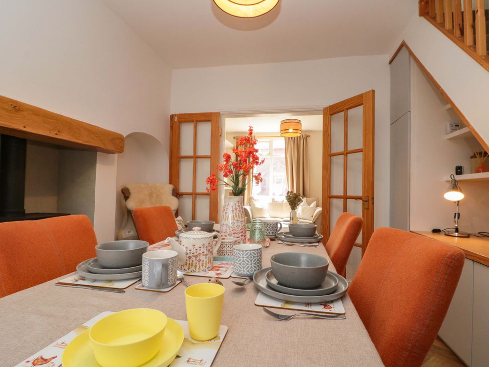 A dining room with a table set for meals at Moot Cottage in Driffield