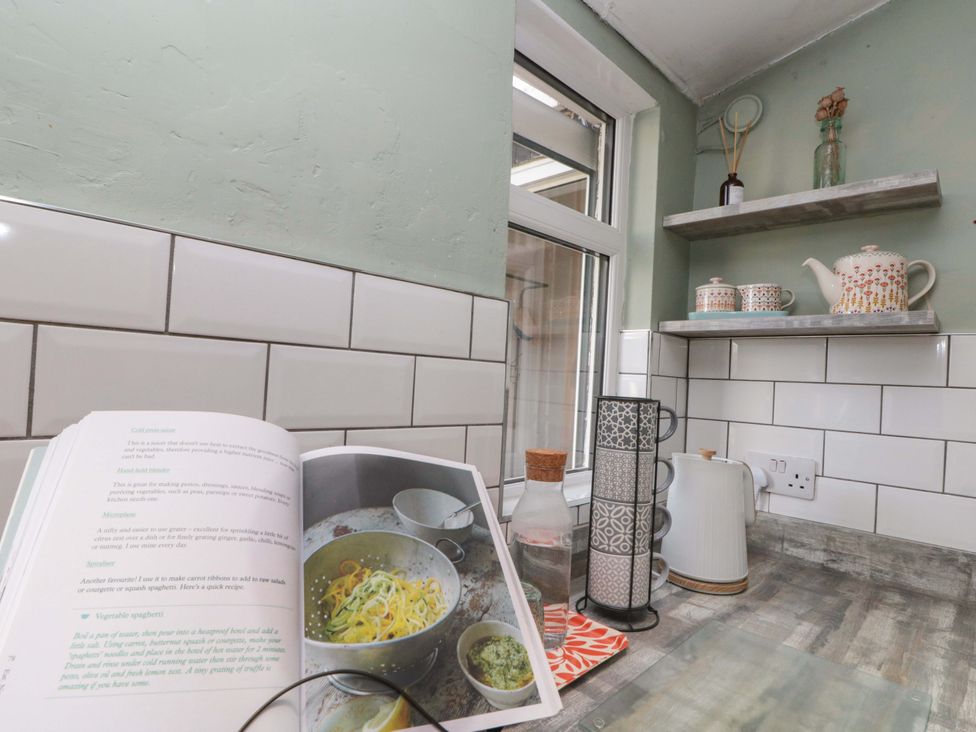 A kitchen with a recipe book open on the counter at Moot Cottage Driffield