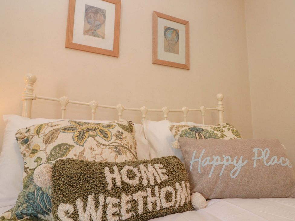A bedroom with a bed and decorative pillows at Moot Cottage Driffield