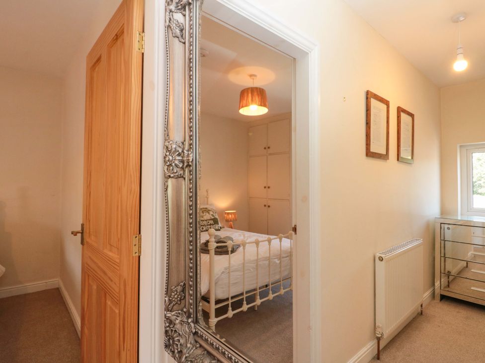 A bedroom with a bed and wardrobe at Moot Cottage in Driffield