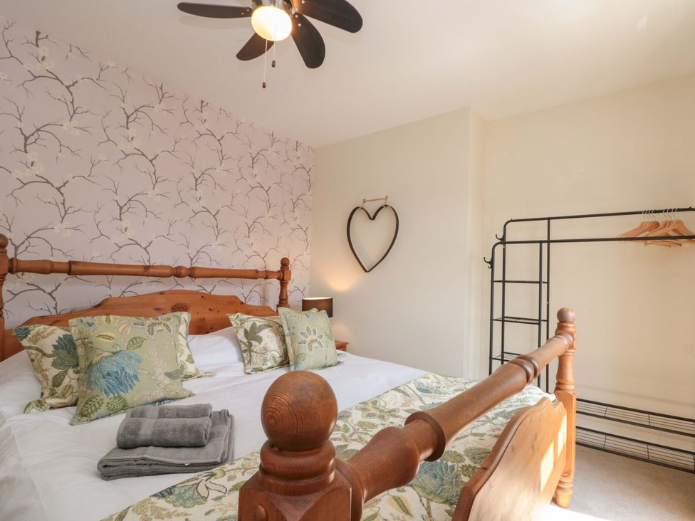 A bedroom with a bed and wardrobe at Moot Cottage in Driffield