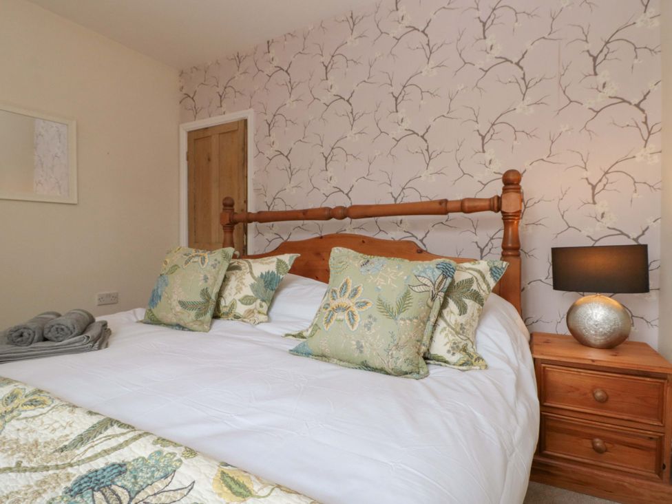 A bedroom with a bed and bedside table at Moot Cottage in Driffield