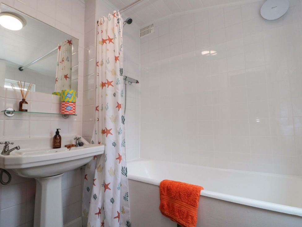 A bathroom with a bathtub and sink at Moot Cottage in Driffield