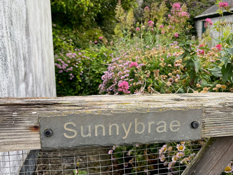 A sign on a wooden gate at Sunnybrae Cottage in Tintagel