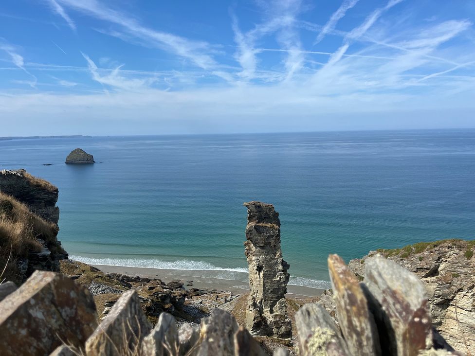 A beach view with a rock formation and ocean at Sunnybrae Cottage in Tintagel