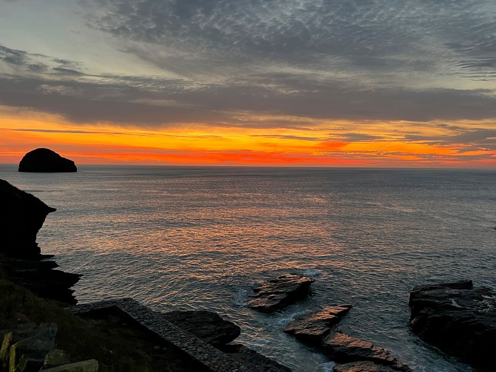A view of the ocean and rocks at sunset at Sunnybrae Cottage in Tintagel