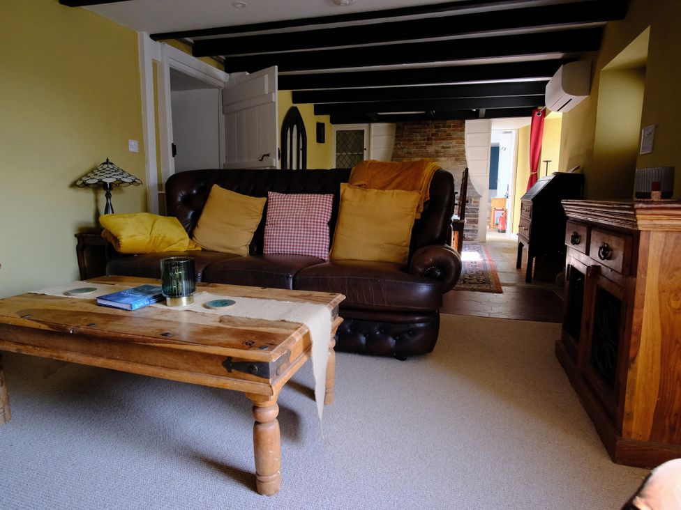 A living room with a sofa and coffee table at Sunnybrae Cottage in Tintagel