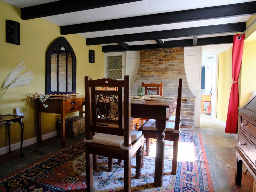 A dining room with a table and chairs at Sunnybrae Cottage in Tintagel
