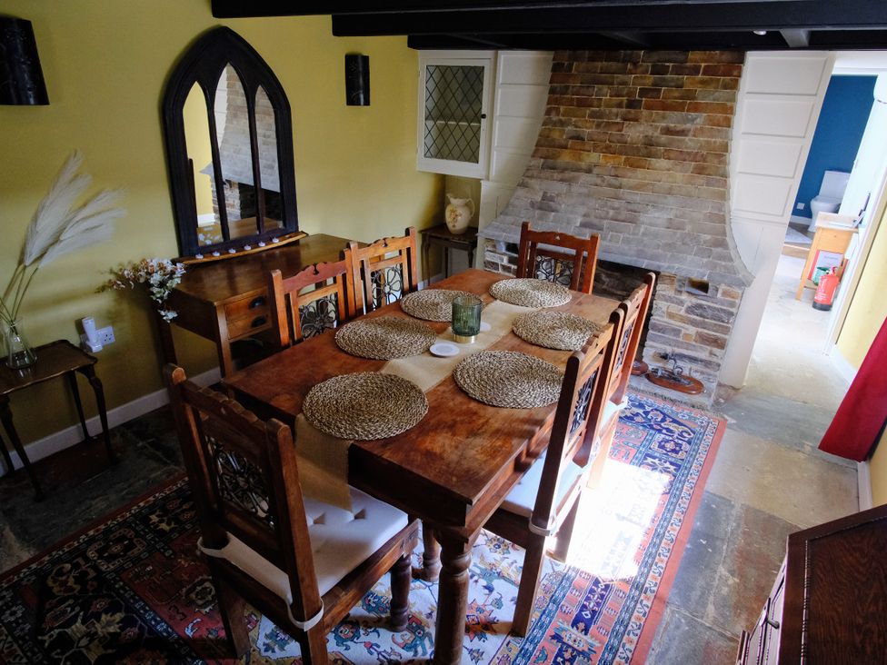A dining room with a wooden table and chairs at Sunnybrae Cottage in Tintagel