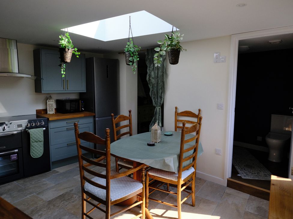 A kitchen with a table and chairs at Sunnybrae Cottage in Tintagel
