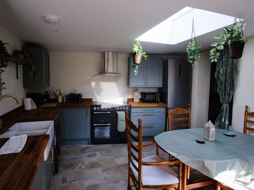 A kitchen with a table and chairs at Sunnybrae Cottage in Tintagel
