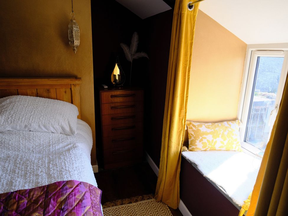 A bedroom with a bed and chest of drawers at Sunnybrae Cottage in Tintagel