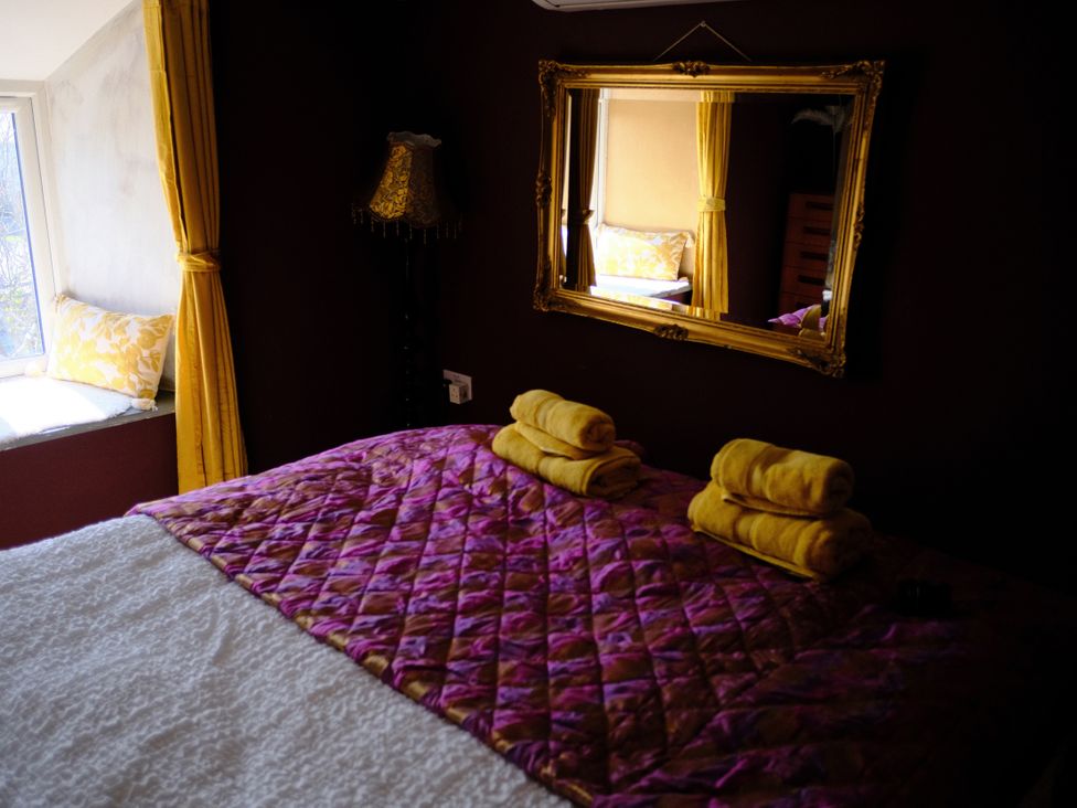 A bedroom with a bed and towels on it at Sunnybrae Cottage in Tintagel