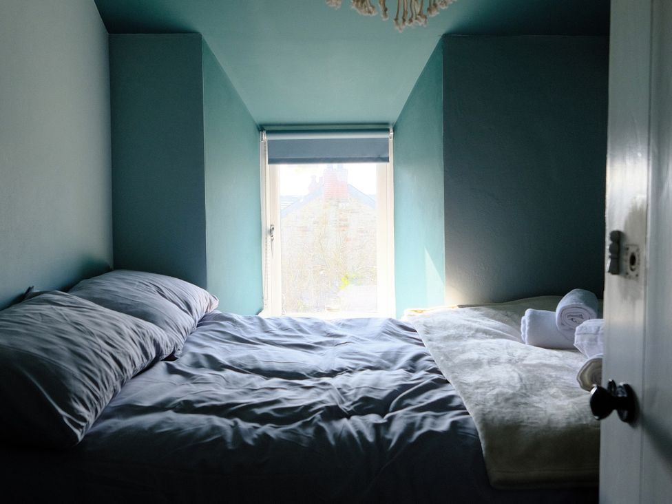 A bedroom with a bed and pillows at Sunnybrae Cottage in Tintagel