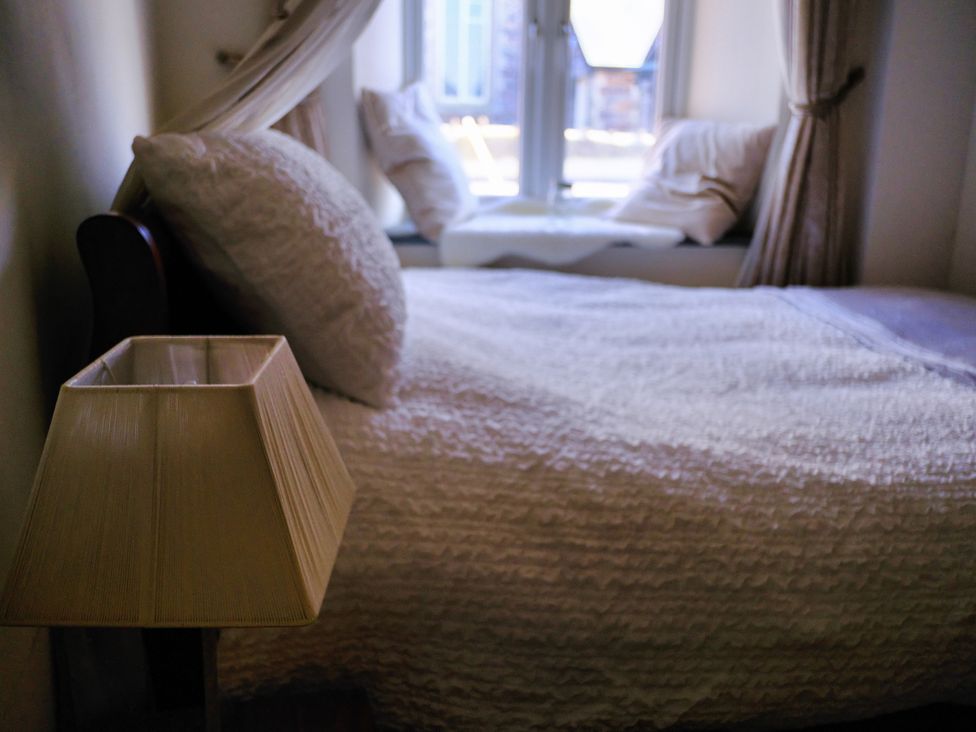 A bedroom with a bed and lamp at Sunnybrae Cottage in Tintagel