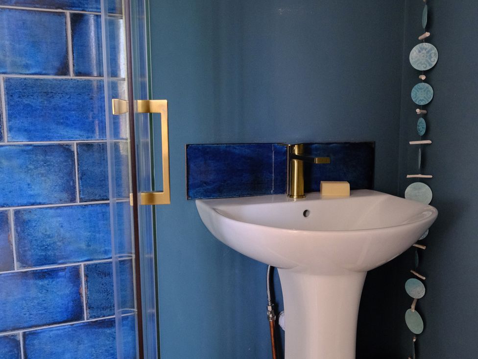 A bathroom with a sink and shower at Sunnybrae Cottage in Tintagel