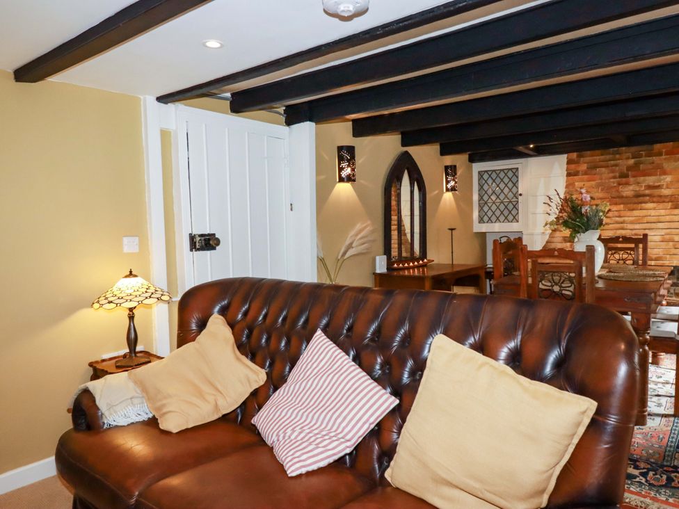 A living room with a sofa and dining area at Sunnybrae Cottage in Tintagel
