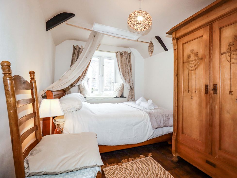 A bedroom with a bed and wardrobe at Sunnybrae Cottage in Tintagel