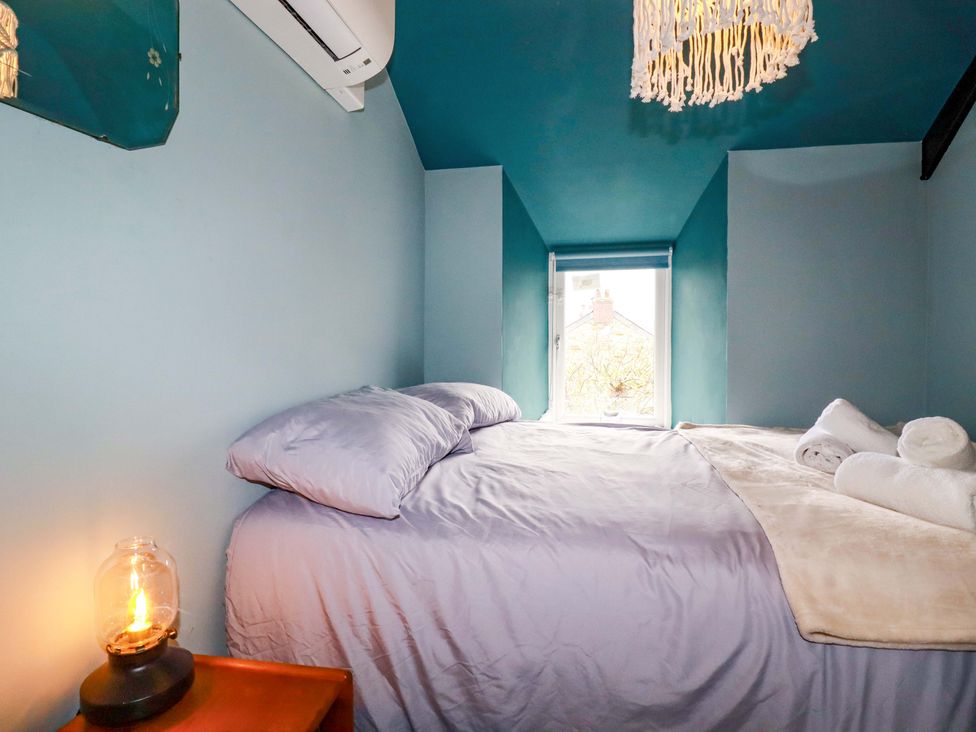 A bedroom with a bed and window at Sunnybrae Cottage in Tintagel