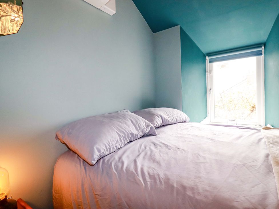 A bedroom with a bed and window at Sunnybrae Cottage in Tintagel