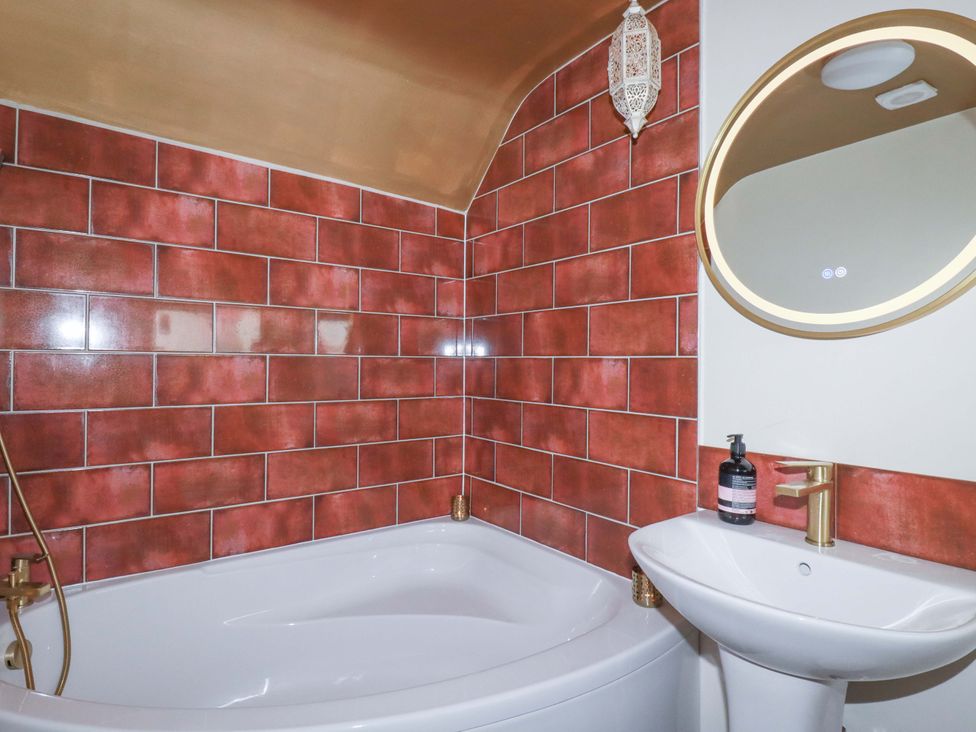 A bathroom with a bathtub and a sink at Sunnybrae Cottage in Tintagel