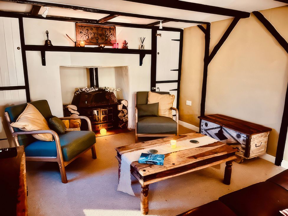 A living room with a fireplace and armchairs at Sunnybrae Cottage in Tintagel