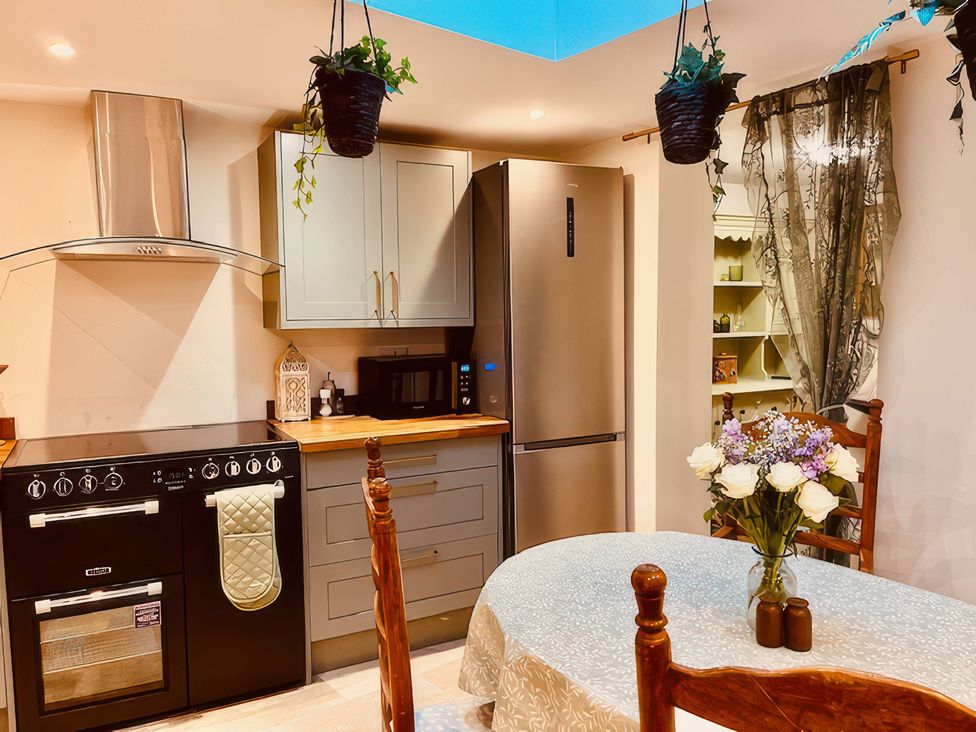 A kitchen with cabinets and appliances at Sunnybrae Cottage in Tintagel