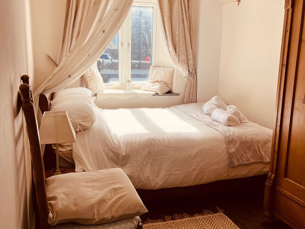 A bedroom with a bed and a wardrobe at Sunnybrae Cottage Tintagel