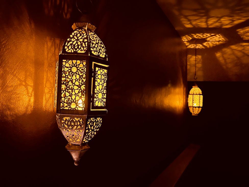 A lantern casting shadows on the wall at Sunnybrae Cottage, Tintagel