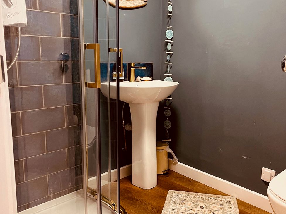A bathroom with a shower and sink at Sunnybrae Cottage in Tintagel