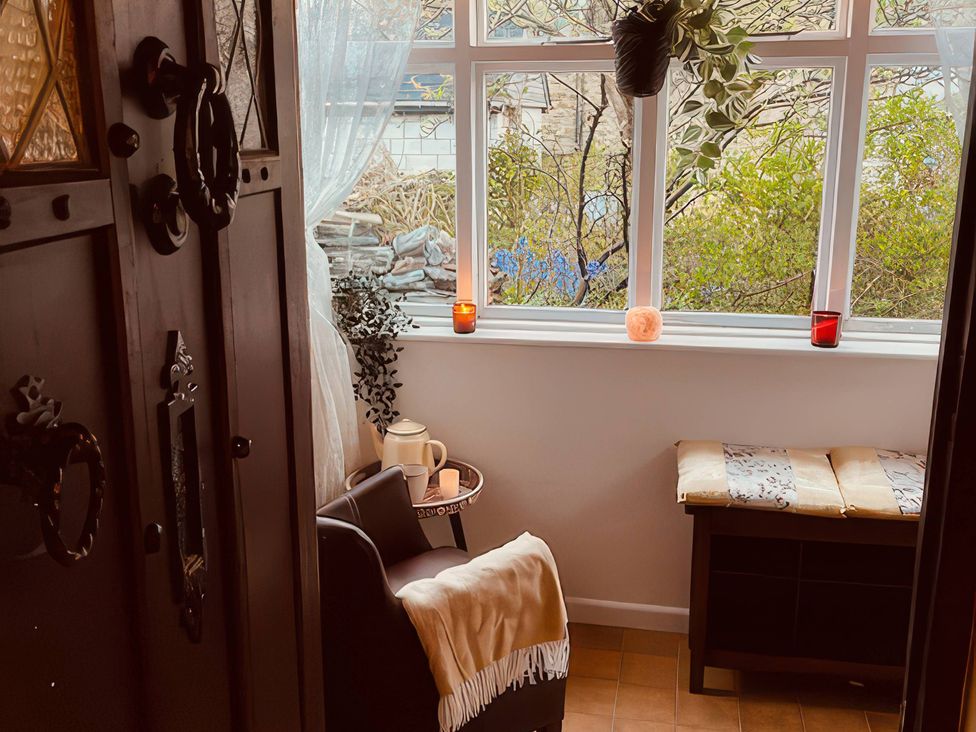 An entryway with a window and chair at Sunnybrae Cottage in Tintagel
