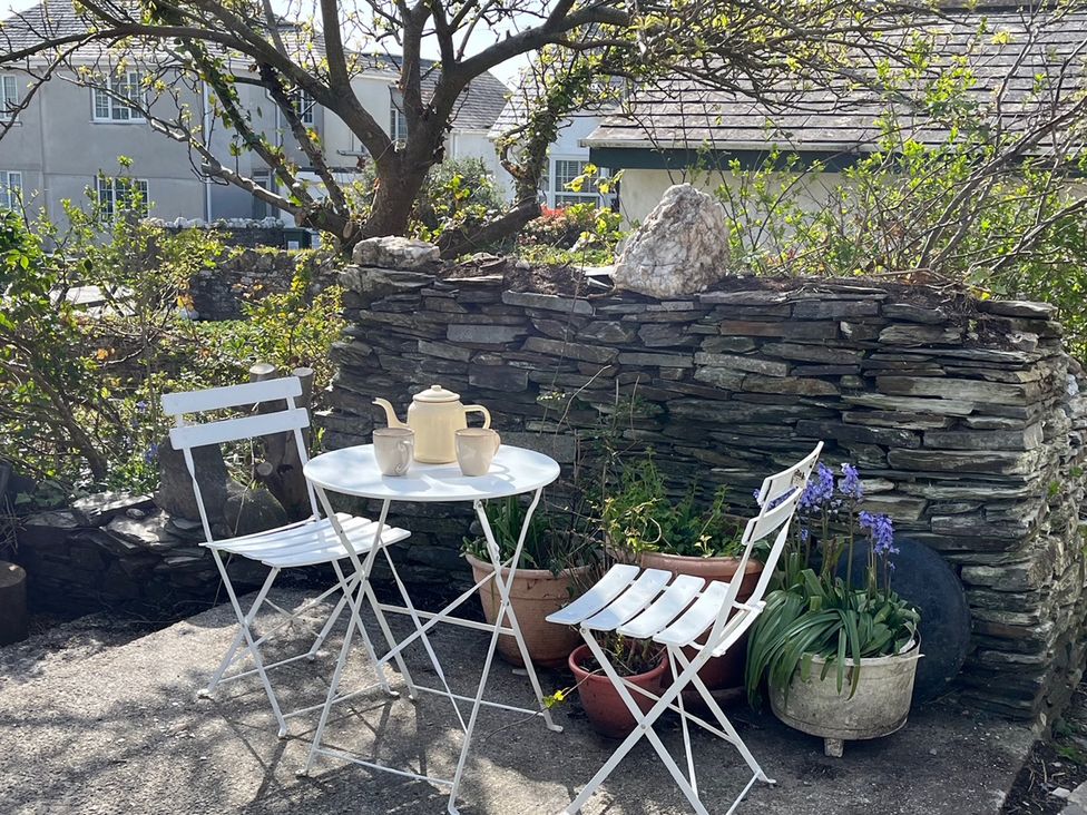 A garden area with a table and chairs at Sunnybrae Cottage Tintagel