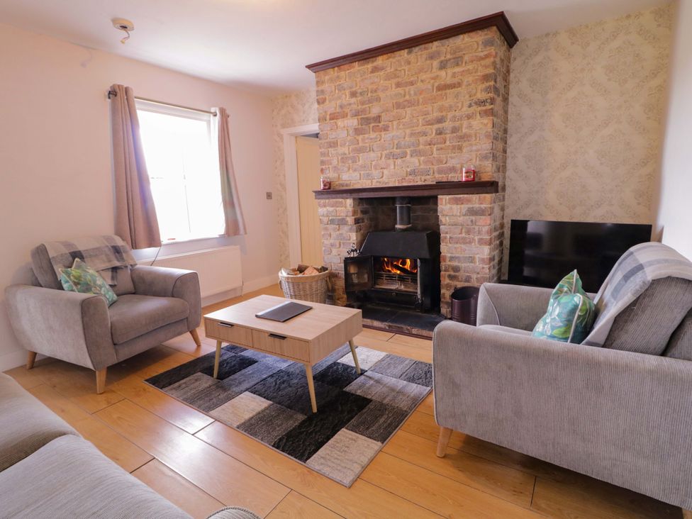 A living room with a fireplace and a coffee table at Molly's Cottage in Enniskillen