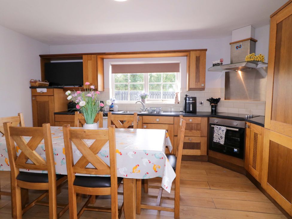 A kitchen with wooden furniture and appliances at Molly's Cottage Enniskillen