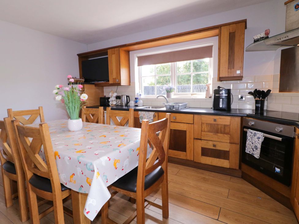 A kitchen with a dining table and appliances at Molly's Cottage Enniskillen