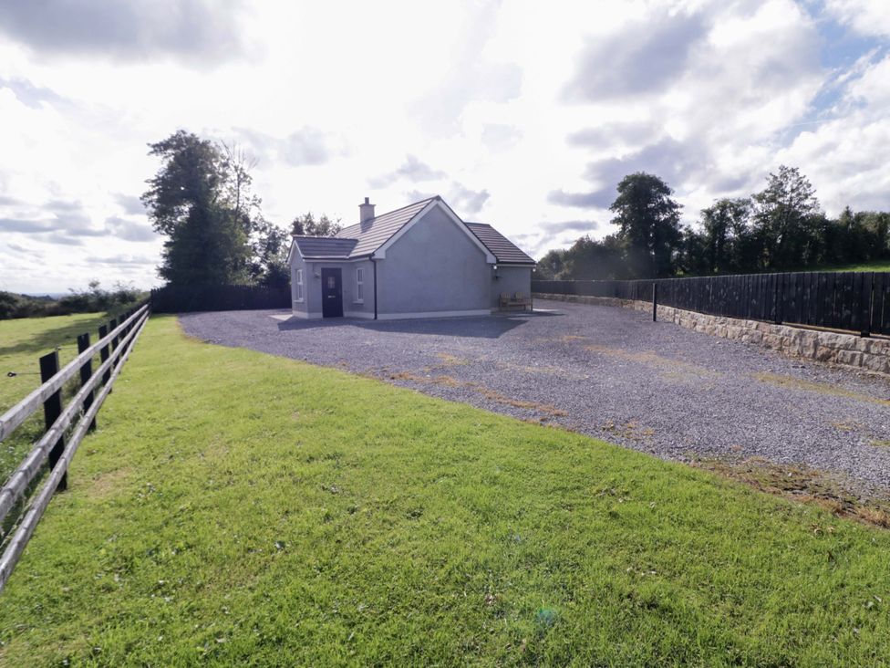 A house with gravel driveway and surrounding green field at Molly's Cottage Enniskillen