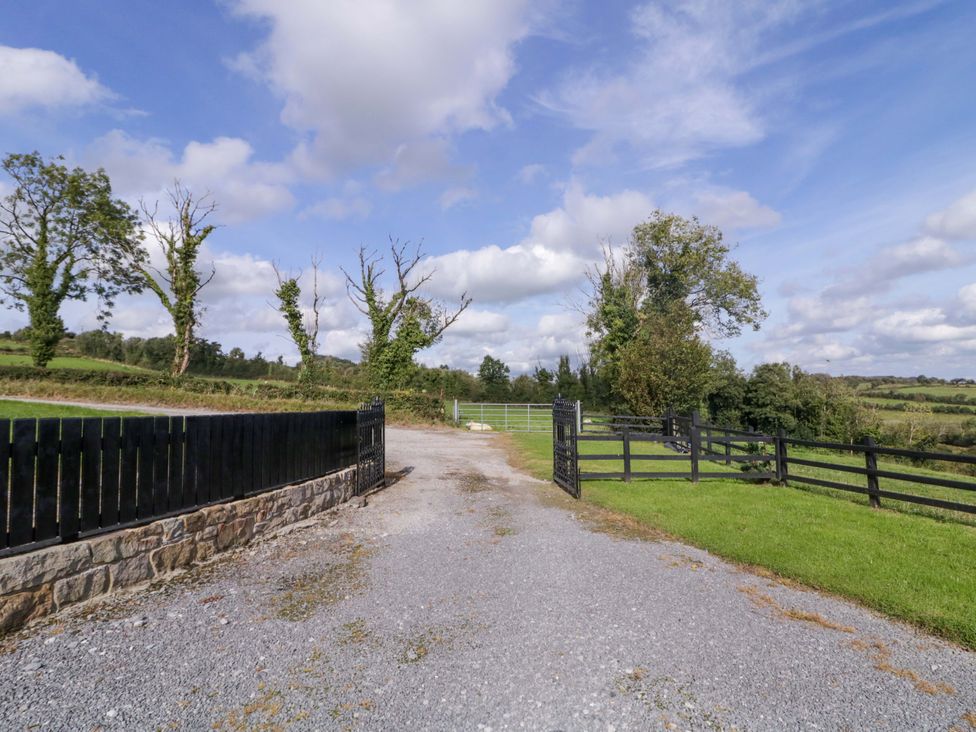 A gravel road with a fence and gate at Molly's Cottage Enniskillen