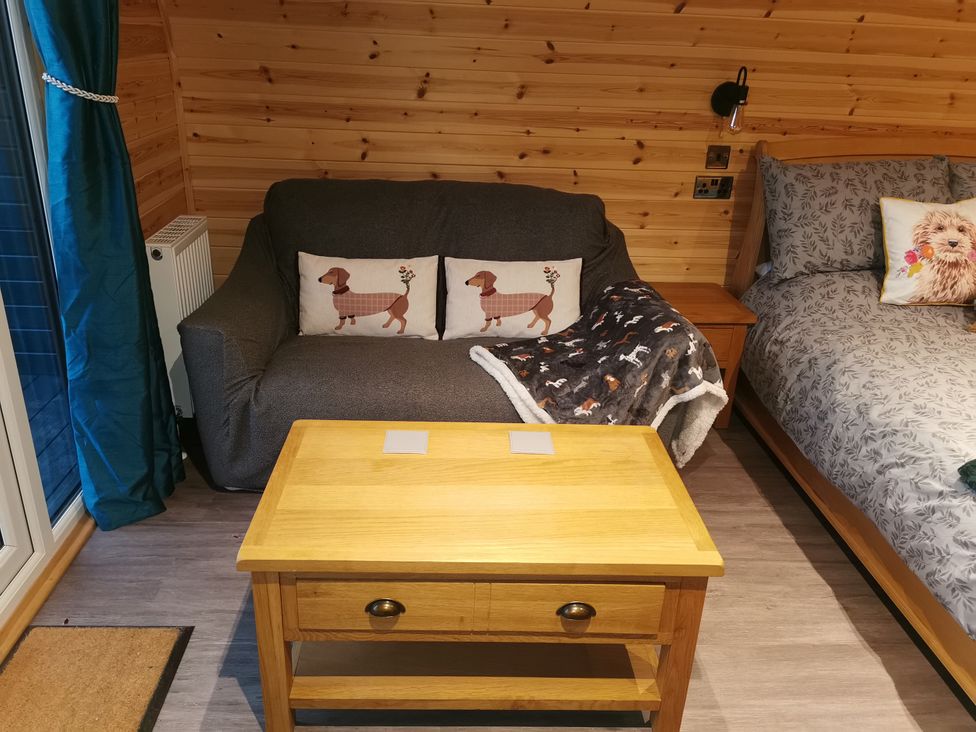 A living room with a sofa and coffee table at Lodge 1 in Pontyates