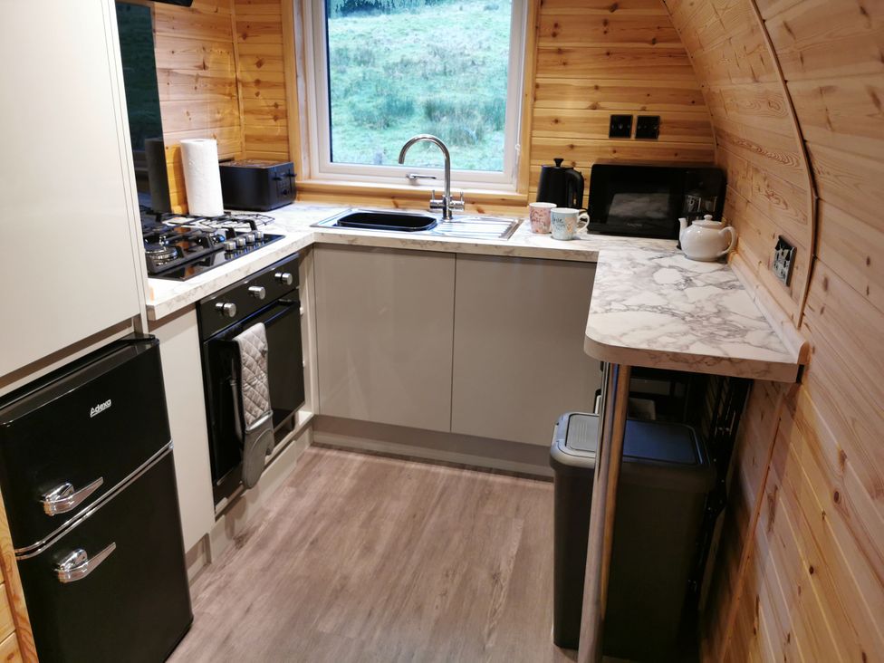 A kitchen featuring a stove, sink, and refrigerator at Lodge 1 Pontyates