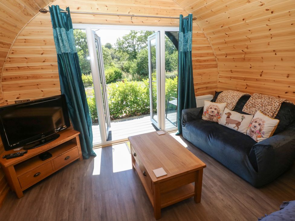 A living room with a television and sofa at Thelma’s Lodge near Pontyates